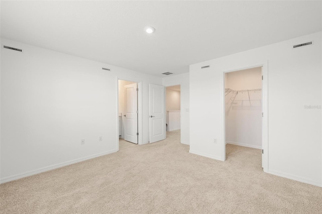 8596 Lunar Skye St, Sarasota, FL 34241 - unfurnished bedroom with a walk in closet, visible vents, and light colored carpet