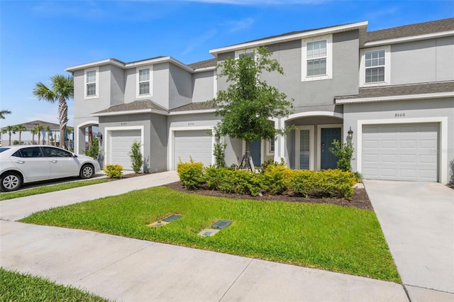 8596 Lunar Skye St, Sarasota, FL 34241 - view of front of house with stucco siding, a front lawn, driveway, and an attached garage