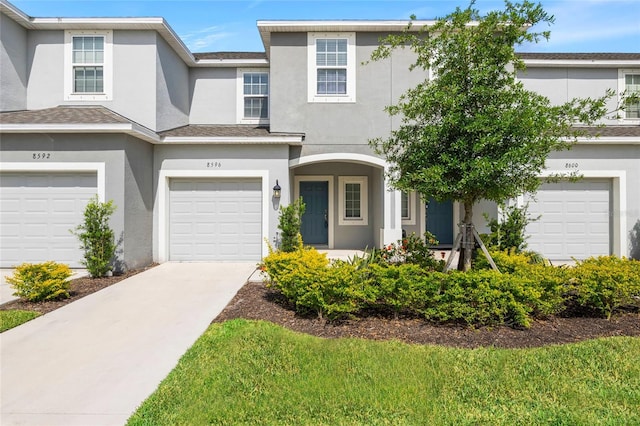 8596 Lunar Skye St, Sarasota, FL 34241 - townhome / multi-family property featuring stucco siding, an attached garage, and concrete driveway