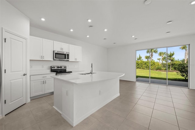 8596 Lunar Skye St, Sarasota, FL 34241 - kitchen with a sink, light tile patterned flooring, a kitchen island with sink, stainless steel appliances, and light countertops
