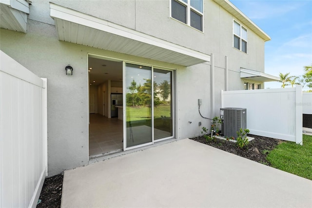 8596 Lunar Skye St, Sarasota, FL 34241 - back of property featuring stucco siding, fence, central air condition unit, and a patio