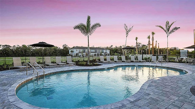 8596 Lunar Skye St, Sarasota, FL 34241 - pool at dusk with fence, a community pool, and a patio