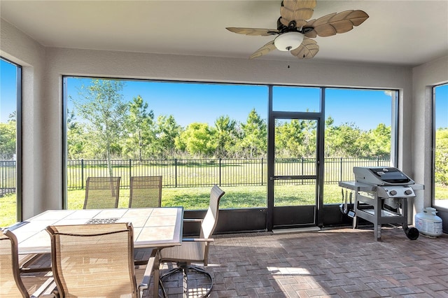 10806 52nd Ct E, Parrish, FL 34219 - sunroom / solarium with ceiling fan, outdoor dining area, and view of wooded area