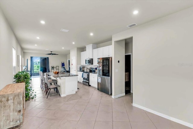 10616 High Noon Trl, Parrish, FL 34219 - kitchen featuring a center island with sink, a kitchen bar, recessed lighting, white cabinets, and appliances with stainless steel finishes