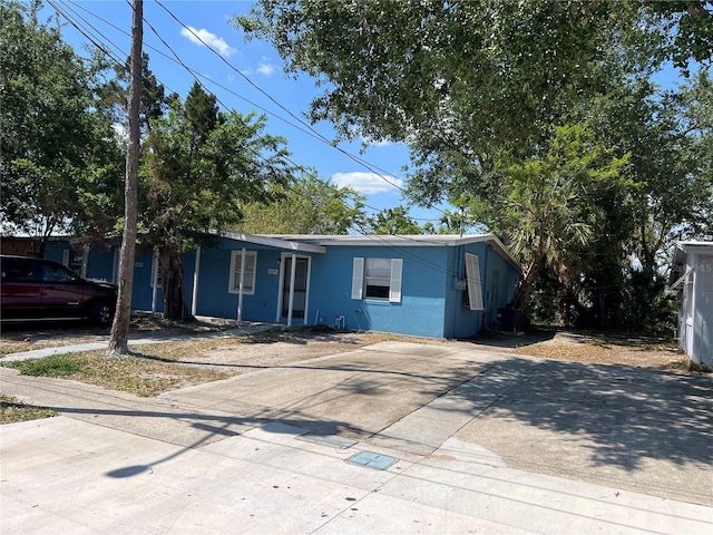 view of front facade featuring stucco siding, central AC unit, and concrete driveway