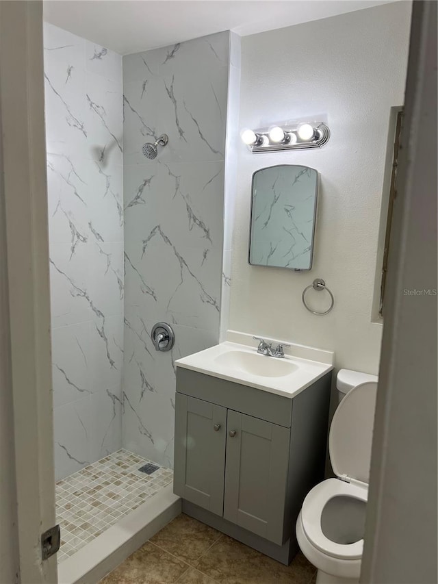 bathroom featuring vanity, tile patterned flooring, a shower stall, and toilet