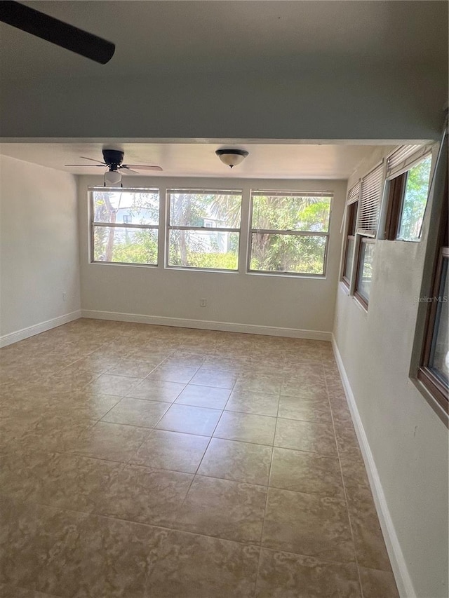 empty room with plenty of natural light and baseboards
