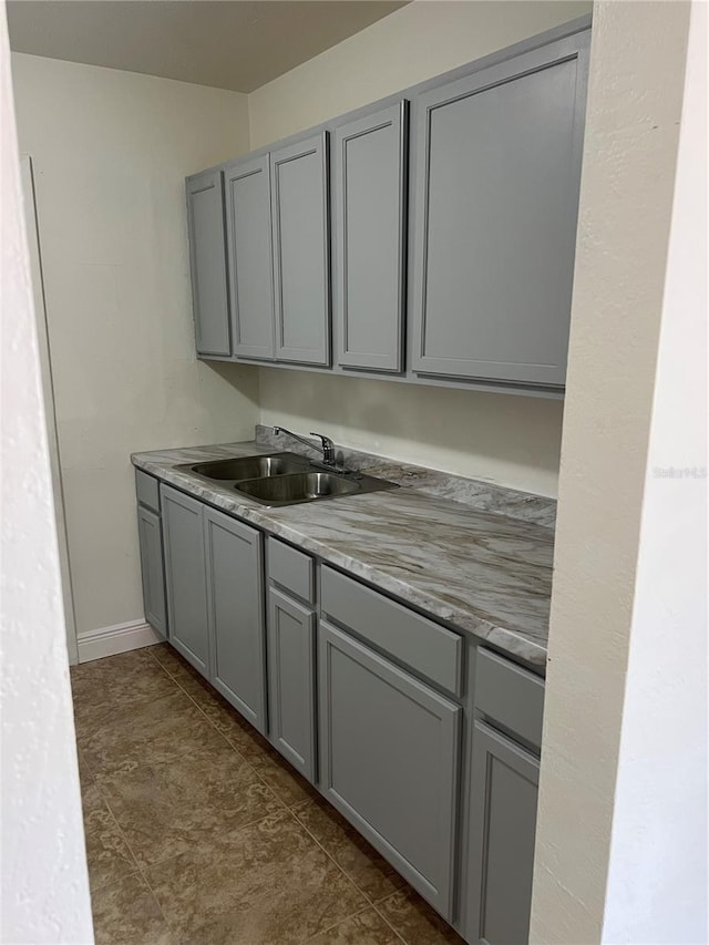bar with baseboards and a sink