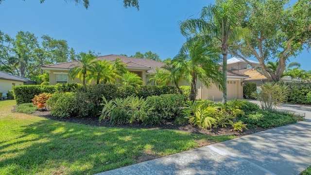 5355 Anthony Ln, Sarasota, FL 34233 - view of front facade featuring a front lawn, stucco siding, concrete driveway, and a tile roof