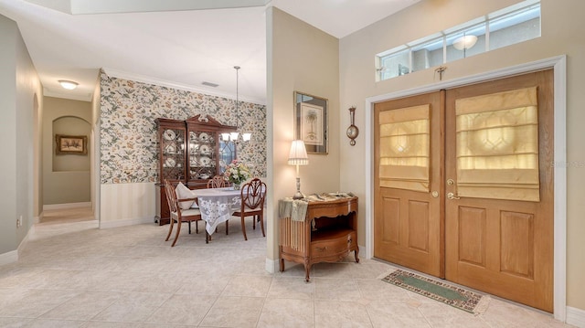 5355 Anthony Ln, Sarasota, FL 34233 - foyer entrance featuring wallpapered walls, tile patterned floors, ornamental molding, and baseboards