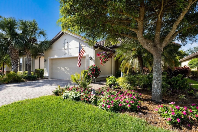 2397 Vaccaro Dr, Sarasota, FL 34231 - view of front of home with a garage, stucco siding, decorative driveway, and a tile roof