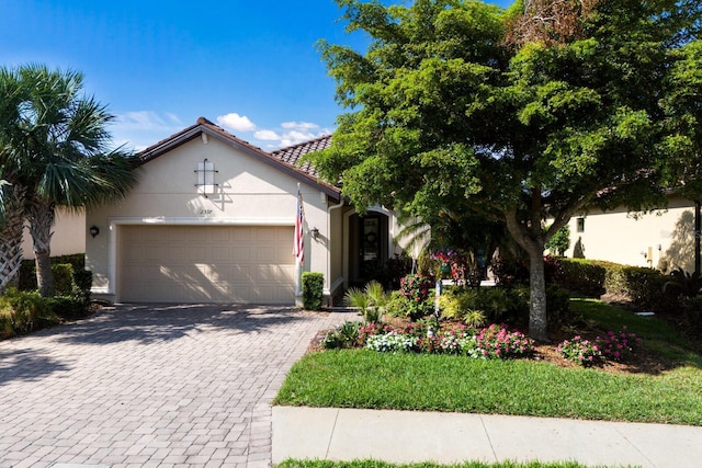 2397 Vaccaro Dr, Sarasota, FL 34231 - view of front of home featuring decorative driveway, a garage, and stucco siding