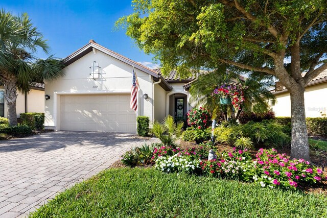 2397 Vaccaro Dr, Sarasota, FL 34231 - mediterranean / spanish-style home featuring stucco siding, a garage, and decorative driveway