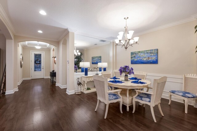 2397 Vaccaro Dr, Sarasota, FL 34231 - dining space with arched walkways, a chandelier, ornamental molding, dark wood-style floors, and recessed lighting