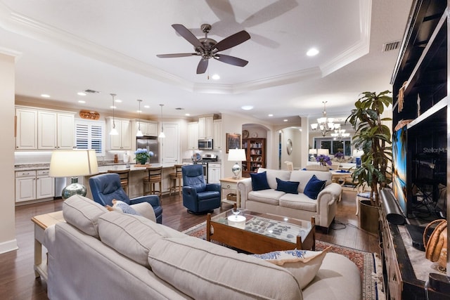 2397 Vaccaro Dr, Sarasota, FL 34231 - living area with arched walkways, a tray ceiling, ceiling fan, a chandelier, and dark wood-type flooring