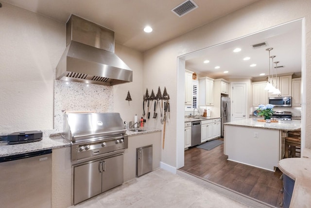 2397 Vaccaro Dr, Sarasota, FL 34231 - kitchen featuring wall chimney range hood, stainless steel appliances, a sink, light stone counters, and recessed lighting