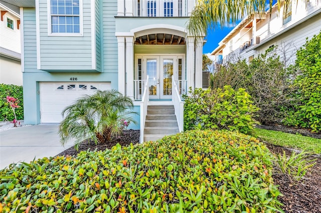 426 Magnolia Ave, Anna Maria, FL 34216 - view of exterior entry featuring an attached garage, driveway, french doors, and a balcony