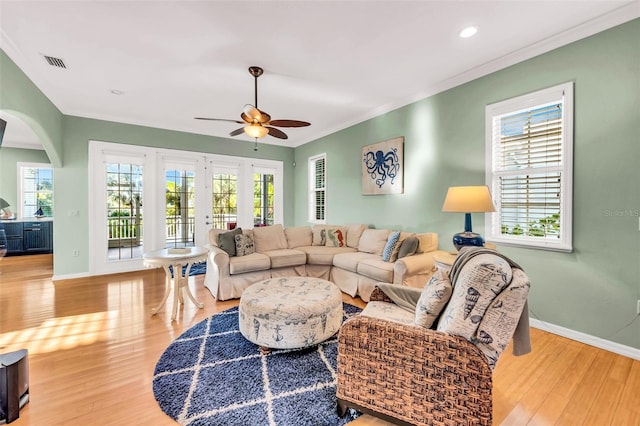 426 Magnolia Ave, Anna Maria, FL 34216 - living room with wood finished floors, visible vents, a ceiling fan, arched walkways, and baseboards