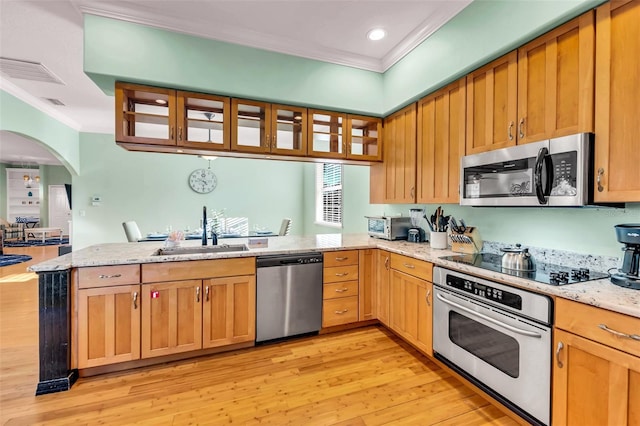 426 Magnolia Ave, Anna Maria, FL 34216 - kitchen featuring a sink, stainless steel appliances, light wood finished floors, a peninsula, and ornamental molding