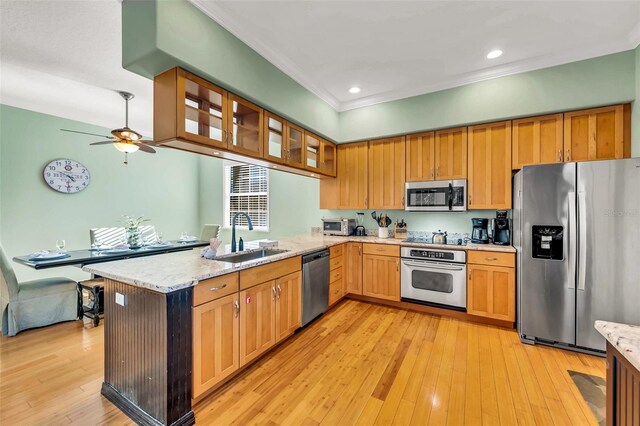 426 Magnolia Ave, Anna Maria, FL 34216 - kitchen featuring stainless steel appliances, a peninsula, light wood-style flooring, a sink, and ceiling fan