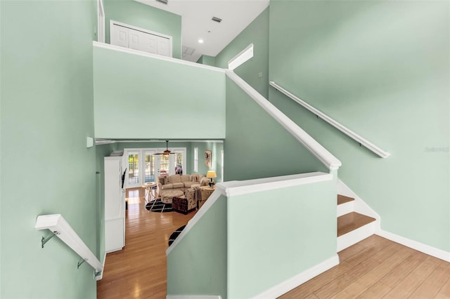 426 Magnolia Ave, Anna Maria, FL 34216 - stairway featuring a towering ceiling, wood finished floors, visible vents, french doors, and baseboards