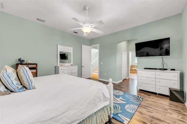 426 Magnolia Ave, Anna Maria, FL 34216 - bedroom featuring wood finished floors, visible vents, arched walkways, ensuite bath, and baseboards