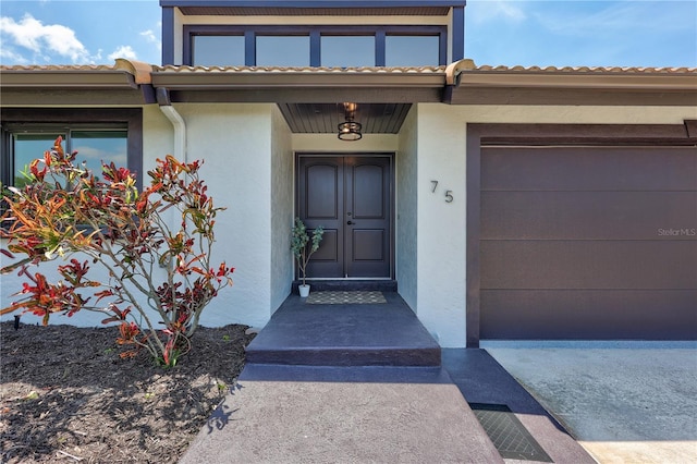 75 Inlets Blvd Unit 75, Nokomis, FL 34275 - entrance to property featuring a tile roof, an attached garage, and stucco siding