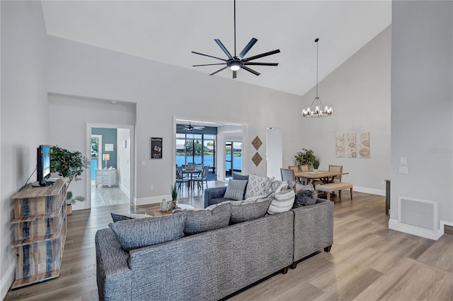 75 Inlets Blvd Unit 75, Nokomis, FL 34275 - living room with high vaulted ceiling, light wood-type flooring, visible vents, and ceiling fan with notable chandelier