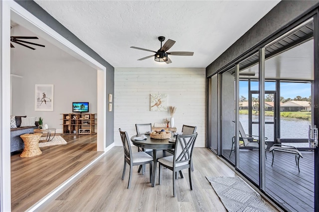 75 Inlets Blvd Unit 75, Nokomis, FL 34275 - dining room with a textured ceiling, light wood finished floors, ceiling fan, and wood walls