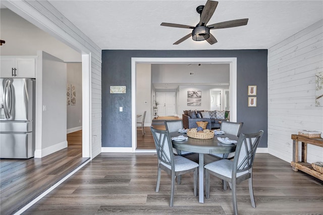 75 Inlets Blvd Unit 75, Nokomis, FL 34275 - dining area featuring dark wood finished floors, wooden walls, a ceiling fan, and baseboards