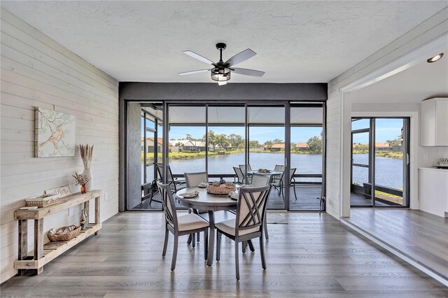 75 Inlets Blvd Unit 75, Nokomis, FL 34275 - dining room with wood walls, a ceiling fan, wood finished floors, and a textured ceiling