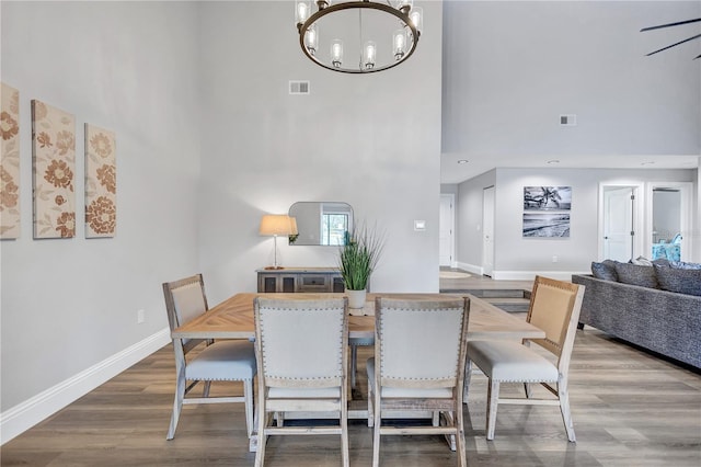 75 Inlets Blvd Unit 75, Nokomis, FL 34275 - dining area with wood finished floors, a high ceiling, an inviting chandelier, baseboards, and visible vents