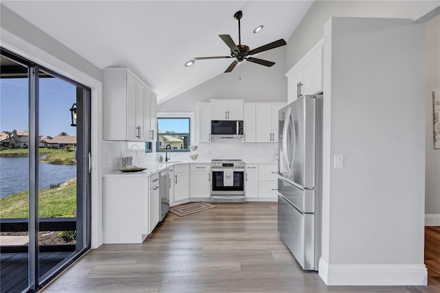 75 Inlets Blvd Unit 75, Nokomis, FL 34275 - kitchen with backsplash, a ceiling fan, a sink, appliances with stainless steel finishes, and white cabinetry