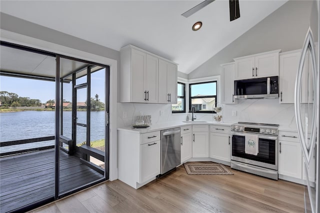 75 Inlets Blvd Unit 75, Nokomis, FL 34275 - kitchen with a sink, light countertops, appliances with stainless steel finishes, light wood finished floors, and white cabinetry