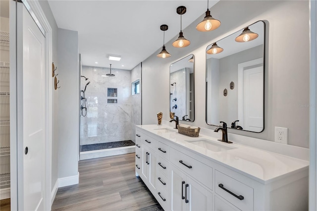 75 Inlets Blvd Unit 75, Nokomis, FL 34275 - bathroom with wood finished floors, a sink, a walk in closet, double vanity, and tiled shower