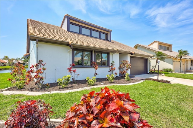 75 Inlets Blvd Unit 75, Nokomis, FL 34275 - view of front facade featuring a tile roof, concrete driveway, a front lawn, and stucco siding