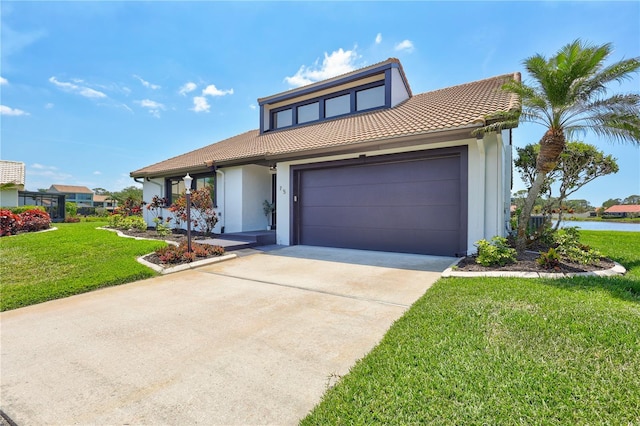 75 Inlets Blvd Unit 75, Nokomis, FL 34275 - view of front of home with a tiled roof, stucco siding, an attached garage, driveway, and a front yard