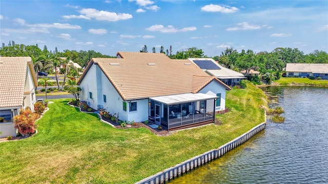 75 Inlets Blvd Unit 75, Nokomis, FL 34275 - back of property featuring a lawn, a water view, a tiled roof, stucco siding, and a sunroom
