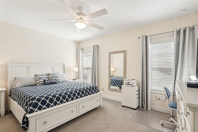 bedroom featuring ceiling fan, light colored carpet, and baseboards