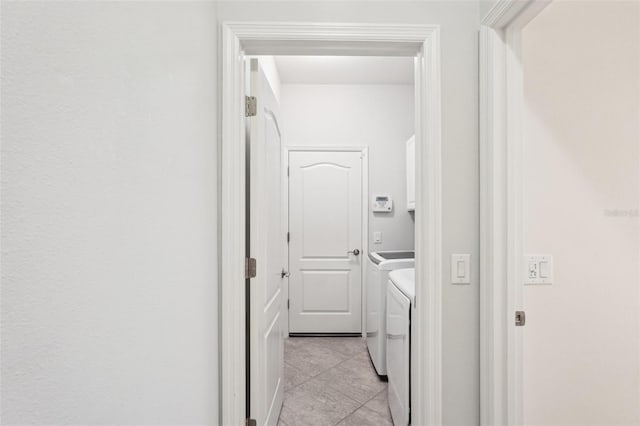 hall with light tile patterned floors and washing machine and dryer