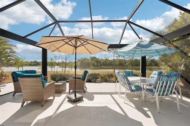 view of patio featuring a lanai, a water view, and outdoor dining area