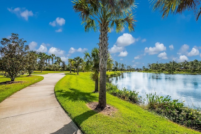 view of property's community with a lawn and a water view