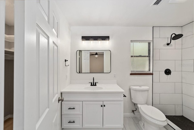 full bath with a tile shower, visible vents, toilet, vanity, and baseboards