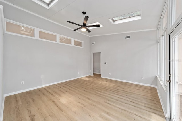 unfurnished room featuring light wood-style flooring, visible vents, a skylight, and a ceiling fan
