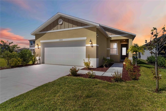 view of front of property with a garage, a front yard, stucco siding, board and batten siding, and concrete driveway