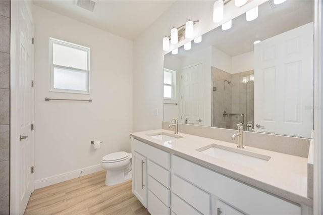 10455 Wet Marsh Cv, Parrish, FL 34219 - full bath featuring double vanity, a stall shower, toilet, baseboards, and wood finished floors