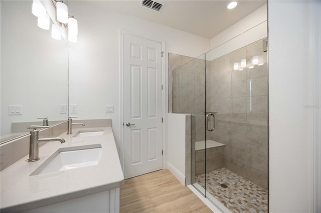 10455 Wet Marsh Cv, Parrish, FL 34219 - full bathroom featuring double vanity, a stall shower, recessed lighting, and wood finished floors
