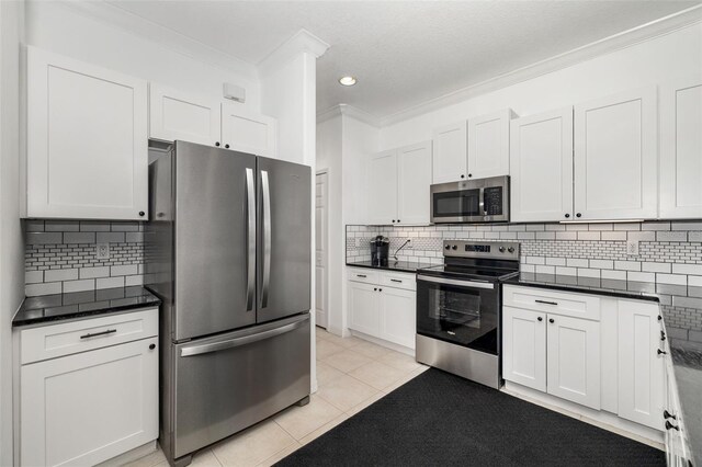 9101 Yarberry St, Sarasota, FL 34240 - kitchen with appliances with stainless steel finishes, light tile patterned floors, crown molding, dark countertops, and backsplash