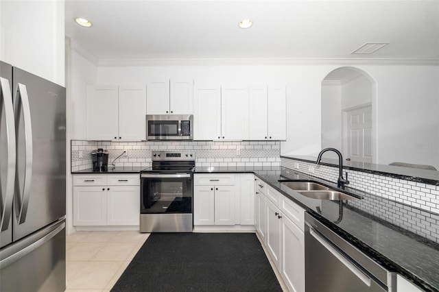 9101 Yarberry St, Sarasota, FL 34240 - kitchen with appliances with stainless steel finishes, a sink, tasteful backsplash, arched walkways, and dark stone countertops