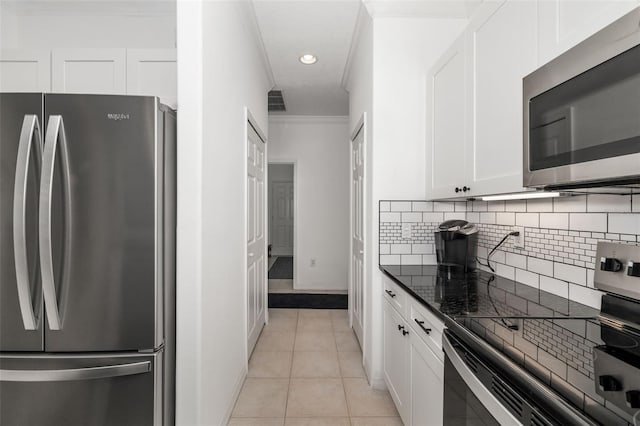 9101 Yarberry St, Sarasota, FL 34240 - kitchen featuring stainless steel appliances, decorative backsplash, white cabinets, baseboards, and dark stone counters